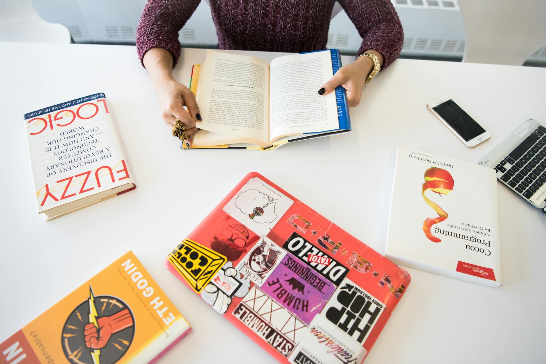 person holding open book on table inside room